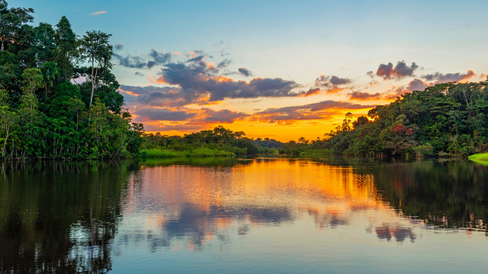 Reflection of a sunset by a lagoon inside the Amazon Rainforest Basin.